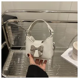 Vue détaillée du mini sac blanc en PU avec nœud argenté et bandoulière amovible