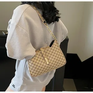 Dettaglio della borsa vintage in tela con motivo monogramma e chiusura in metallo oro