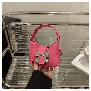 Détail du mini sac en cuir PU rose avec boucle nœud argenté et chaîne en métal élégante