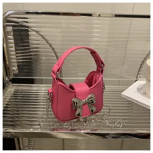 Détail du mini sac rose avec nœud métallique argenté et cuir synthétique texturé