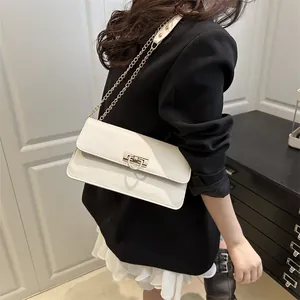 French style cream baguette shoulder bag with gold horseshoe clasp shown on a model