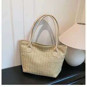 Dettaglio ravvicinato della trama intrecciata beige e dei manici in pelle PU della borsa