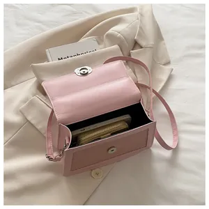 Detail view of pink flap crossbody bag interior with silver magnetic closure and phone storage