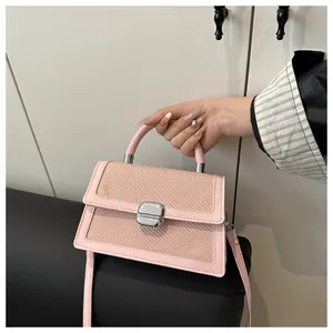 Detail of pink PU leather and woven texture handbag with silver twist-lock and shoulder strap