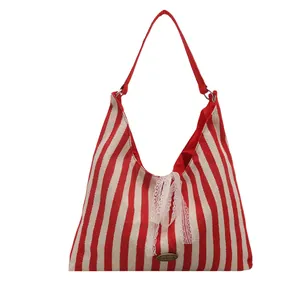 Red and white striped canvas tote bag with white lace bow and sturdy red handles