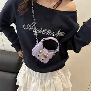 Mini sac bandoulière lavande avec nœud argenté et chaîne porté par un mannequin femme