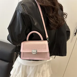 Pink minimalist crossbody bag with woven texture and silver hardware shown with a model