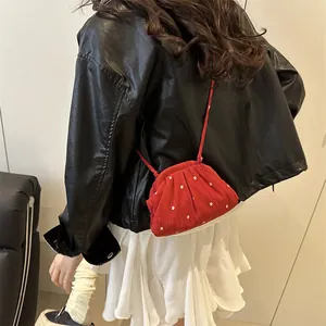 Mini sac bandoulière rouge rétro à pois avec fleurs porté par un mannequin