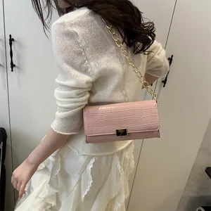 Pink stone pattern flap shoulder bag with gold chain strap shown on model in summer style