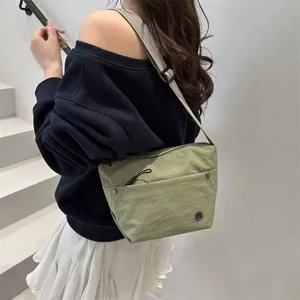 Minimalist bean green nylon crossbody bag for women with adjustable strap and front pocket