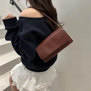Chic burgundy woven texture shoulder bag worn by model against a minimalist background