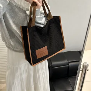 Retro black corduroy tote bag with brown straps and fashion label for daily commute