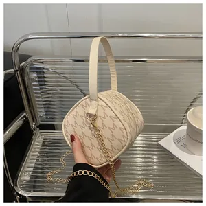 Detailed view of mini round cylinder bag with beige M-monogram and golden chain strap