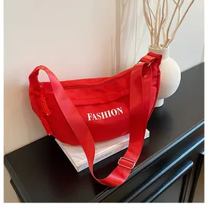 Close-up of red fashion dumpling bag with adjustable shoulder strap and FASHION logo