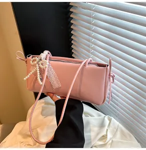 Detailed view of pink shoulder bag with pearl bow and lace ribbons on smooth PU leather