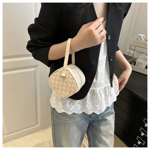 Detail of a mini beige cylindrical monogram bag with M print and a long strap