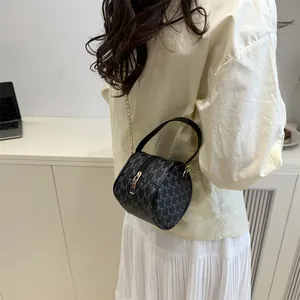 Mini round cylinder crossbody bag with monogram pattern and gold chain strap for women