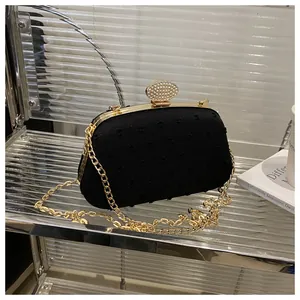 Detail of black evening clutch with rhinestone oval clasp and vintage gold frame