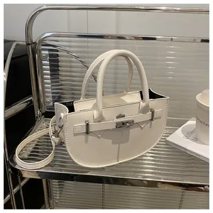 Vista dettagliata di una borsa bianca a mezzaluna con chiusura girevole in metallo