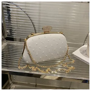 Detail of white woven evening bag with gold hardware and sparkling diamond buckle