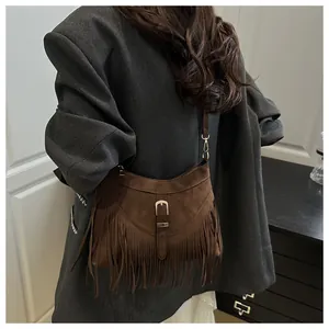 Brown suede shoulder bag featuring long fringe details and vintage buckle in boho style
