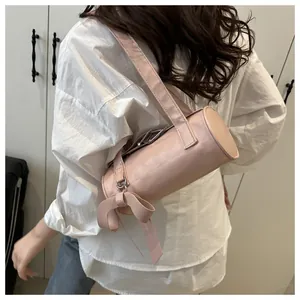 Detail of pink cylindrical shoulder bag with silk bow and silver metal buckle