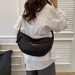 Minimalist black crescent canvas shoulder bag with fashion lettering and wide strap