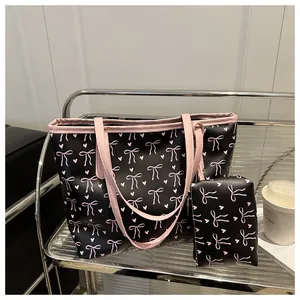 Detail of black tote bag set with pink bow print and matching mini storage pouch