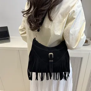 Fashionable black suede shoulder tote bag with long fringe tassels and metal buckle detail