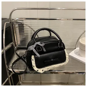 Detailed close-up of a black PU handbag featuring lace trim and a cute checkered bow decoration