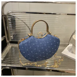 Detail of blue denim evening clutch with gold metal handle and sparkling rhinestone buckle