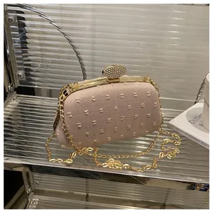 Detail of light pink party clutch with textured dots, gold frame and crystal clasp