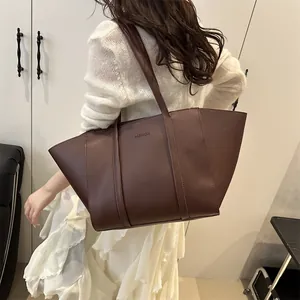 Brown leather tote bag with FASHION logo and slim shoulder straps for daily commute