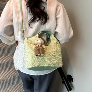 Light green pleated bucket bag with cute teddy bear charm shown worn as crossbody