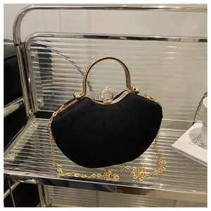 Macro detail of black evening bag featuring shimmering rhinestones and gold metal handle