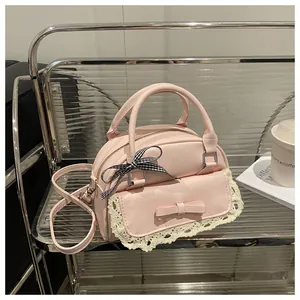 Detailed shot of pink handbag featuring a lace accent, bow decoration, and checkered ribbon
