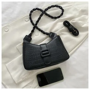 Detail of black croc-effect hobo bag with thick woven strap and adjustable crossbody strap