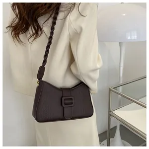 Detail view of dark brown faux leather shoulder bag featuring crocodile embossed pattern