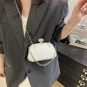 Elegant white textured evening clutch bag with diamond-encrusted buckle and gold chain