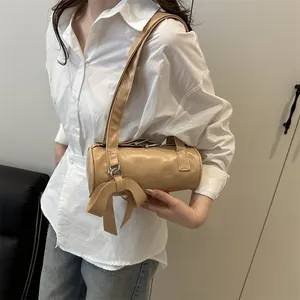 Chic beige cylindrical underarm bag with decorative bow and fixed shoulder strap