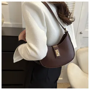 Detail of vintage dark brown faux leather hobo bag with gold buckle hardware on model