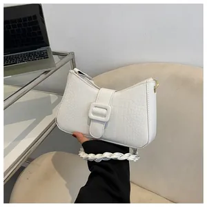 Detailed view of white crocodile pattern bag with unique braided leather shoulder strap