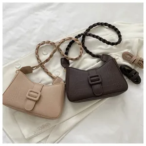 Detail of vintage crocodile embossed baguette bags with woven handles in beige and brown