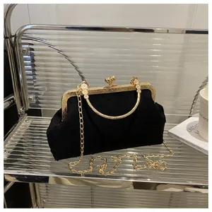 Dettaglio della pochette vintage in velluto nero a pois con chiusura in metallo dorato