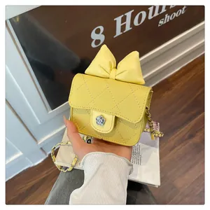 Detail of yellow quilted leather bag with bow accent and flower-shaped metal clasp
