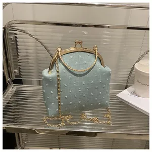 Dettaglio borsa a conchiglia azzurra con trama a pois 3D e chiusura a scatto dorata