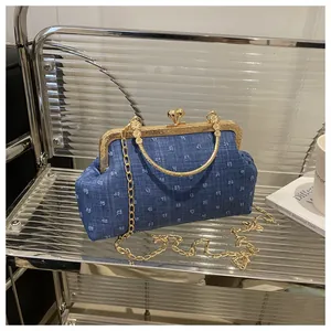 Dettaglio della borsa da sera in denim blu con telaio in metallo dorato e chiusura
