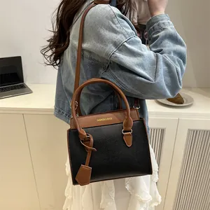 Chic black and brown leather crossbody bag shown in a professional lifestyle setting