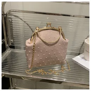 Dettaglio borsa vintage rosa con trama a pois 3D e manico rotondo in metallo dorato