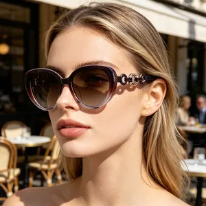 Detail of cat-eye sunglasses with purple gradient frame and metal chain temple decor